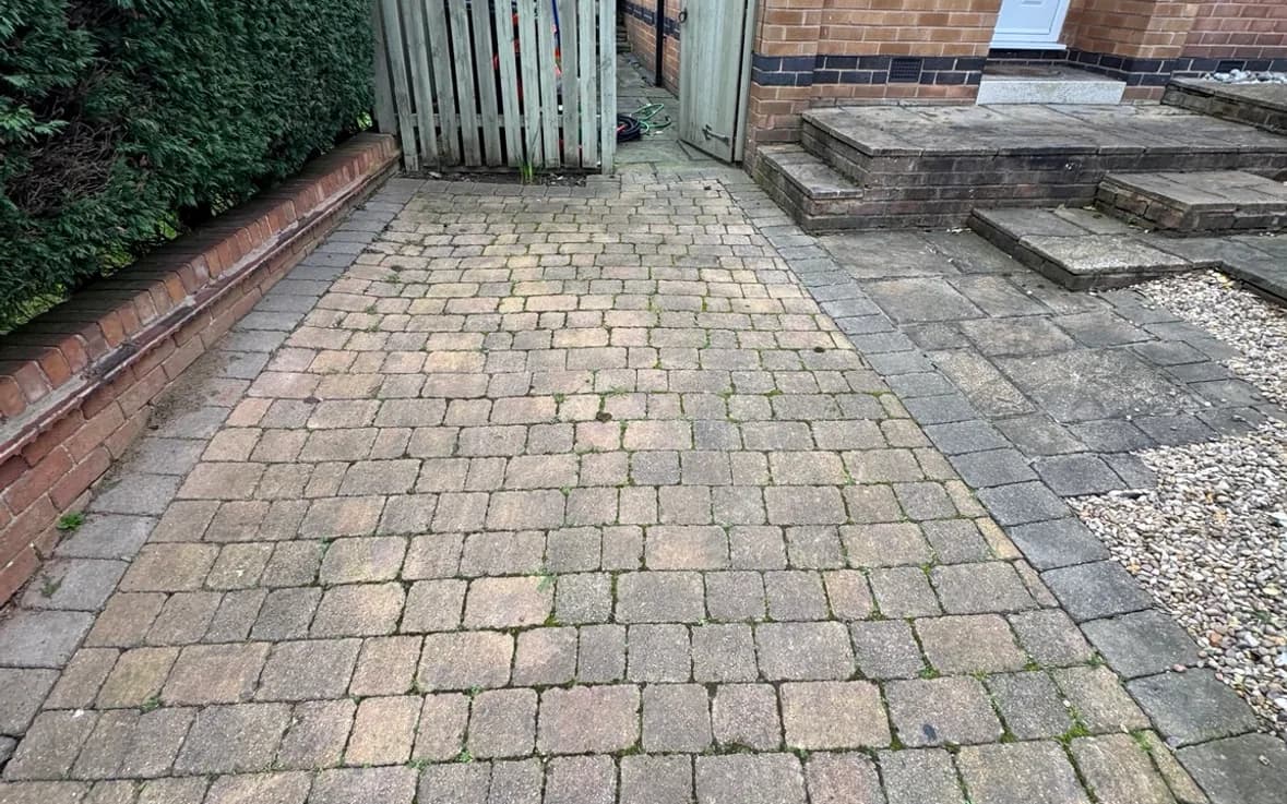 Block paved driveway in Nottingham green with moss and ingrained dirt before pressure washing